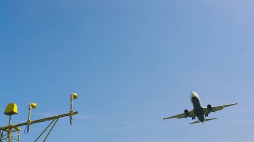 Airplane approaches landing at sunny airport on clear blue day