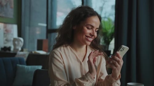 Woman Smiling and Using Mobile Phone Indoors