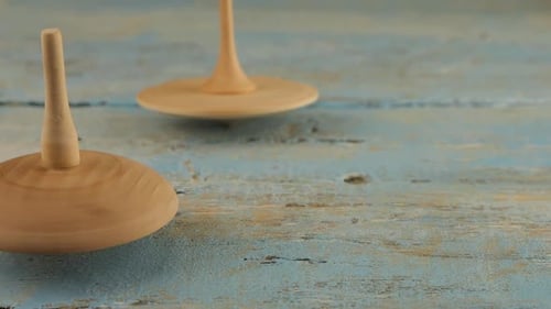 Wooden Tops Spinning on a Blue Wooden Surface