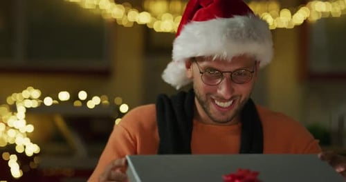 Young Adult Excitedly Opening Christmas Gift