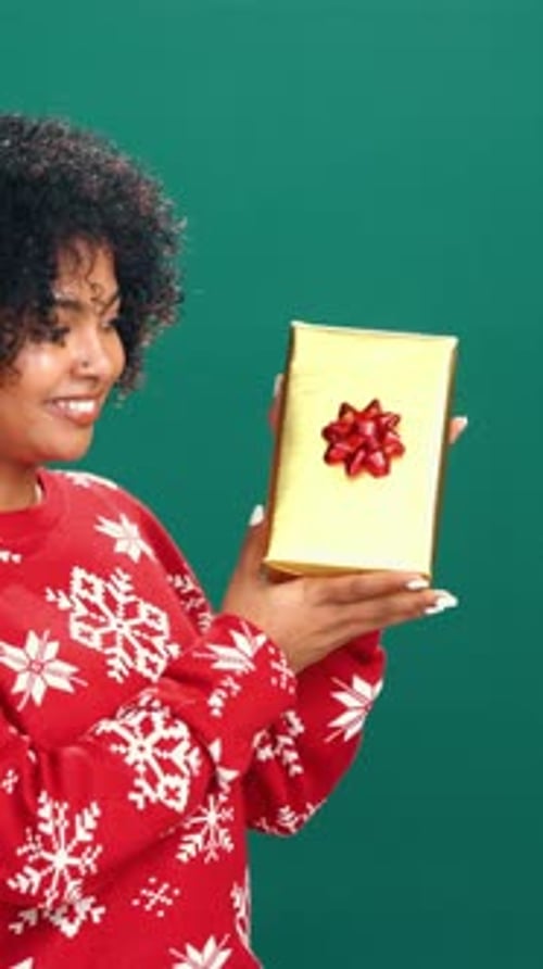 Christmas, gift and face of woman in studio with guess for holiday, tradition and festive season