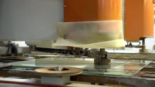 Rotating drill making holes in glass. Glassworking industry. Drilling a hole into glass panel on a m