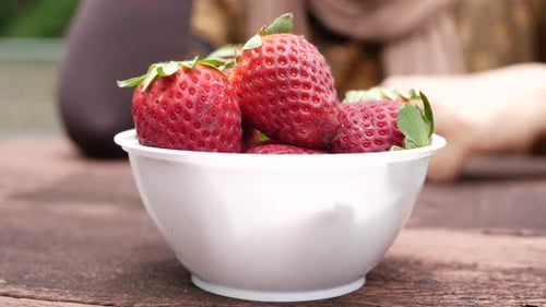 Women Hand Pick Strawberries in a Bowl on Table