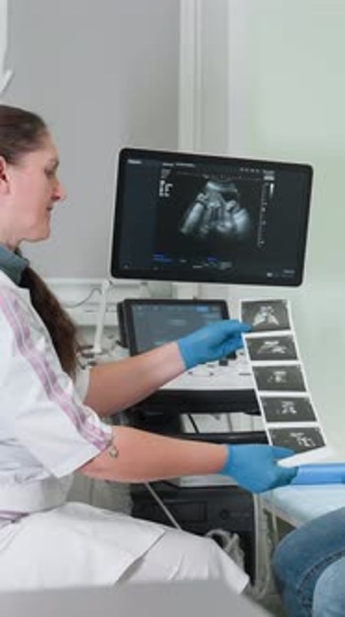 Échographe effectuant une échographie foetale avec soin Cadre clinique où l'échographiste examine le fœtus