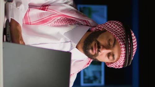 Man Working on Laptop at Desk at Night
