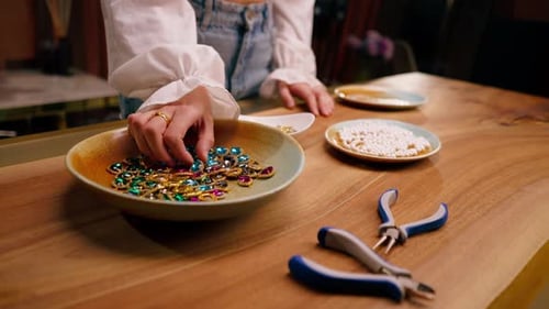 close-up of female hands creative girl needlewoman chooses beads for bracelet craft jewelry