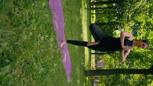 vertical video an experienced female instructor meditates park practices yoga does stretching