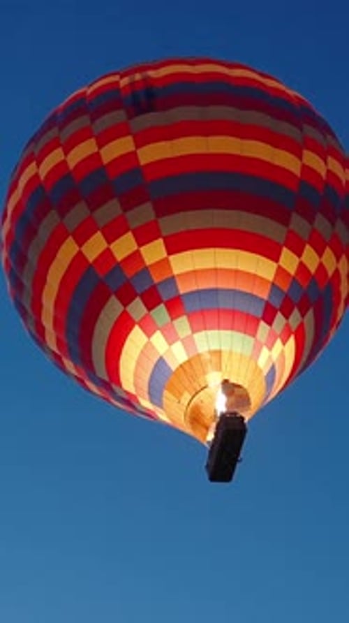 Vídeo vertical. Al amanecer, con las estrellas aún visibles en el cielo, se lanza un enorme globo aerostático