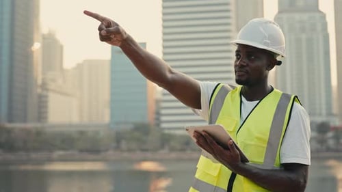 Portrait of Afro American Builder with Tablet Pointing Aside