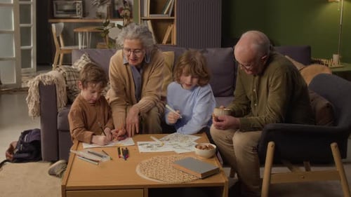 Senior Grandparents Helping Grandchildren Drawing on Paper at Home