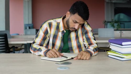 Thoughtful Tired Young Indian Student Preparing to the Exam at the University Library