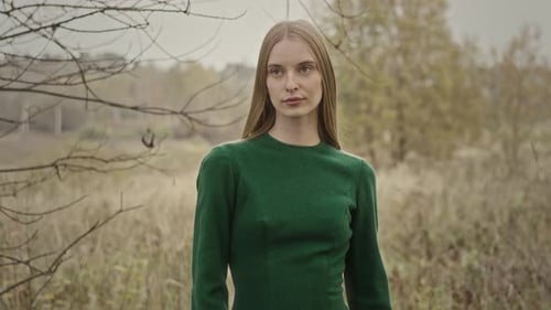 Model posing for photo shoot in nature wearing green dress
