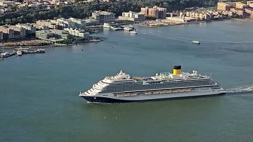 Large Cruise Ship Sailing Near Coastal City A Large Cruise Ship Moving Along a River Near a Modern