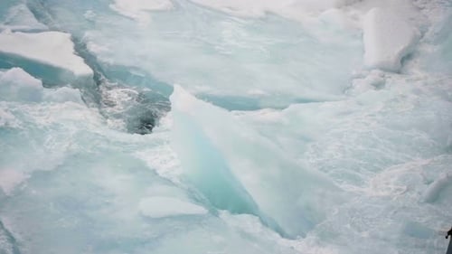 Icebreaking Vessel Bow Pushing Through Fragmented Sea Ice and Turquoise Floes Churning Polar Water