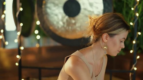 Blonde Woman Relaxing Near a Gong