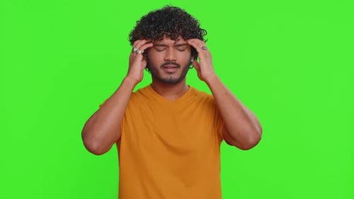 Man Massaging Temples in Front of Green Screen