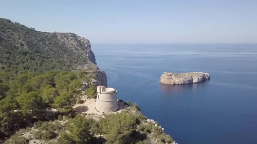Torre des Molar on cliff at rocky coast. Port de Sant Miquel, Ibiza.