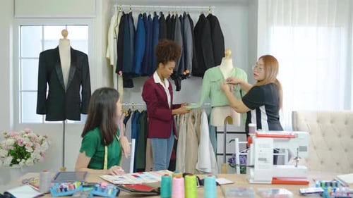 Team of three fashion designers preparation for create new clothes collection in workshop studio