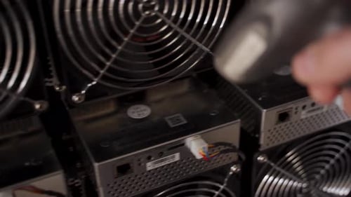 Controller in Uniform Scans ASIC Bitcoin Miners with Barcode Scanner in Warehouse Warehouseman
