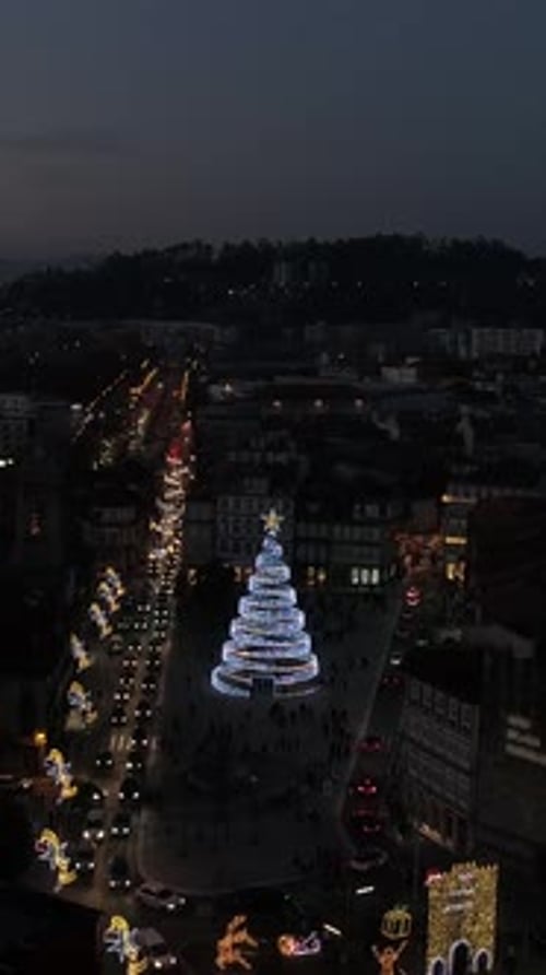 Vertical Video of Large Christmas Tree Full of Decorations and Lights in a City Centre at Night