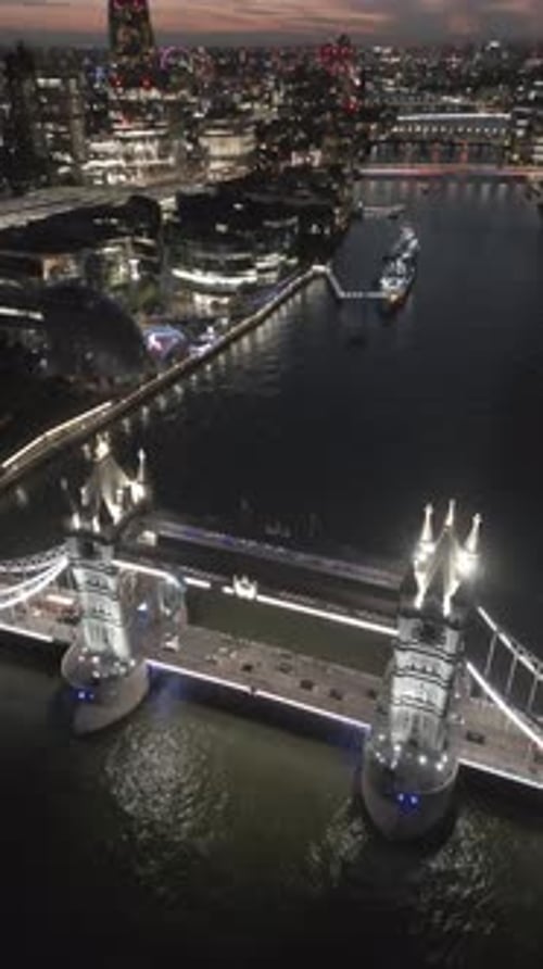Aerial video of the city of London and the lighthouse bridge in London at night