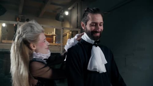Woman Adjusts a Man's Historical Period Costume