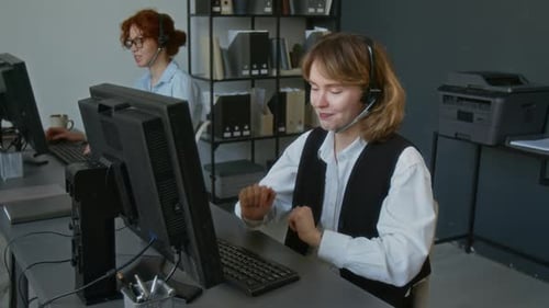 Positive Young Female Customer Service Agent Consulting Client in Call Centre