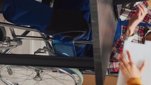 Vertical Video Man with Chronic Disability Using Laptop in Warehouse