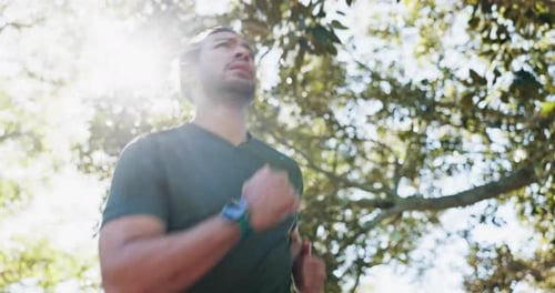 Focused Man Jogging in Park on Sunny Day