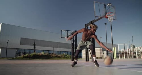 Un sportif afro-américain dribble sur le court