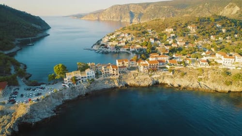 Picturesque coastal village with colorful houses and clear water bay surrounded by mountains at gold
