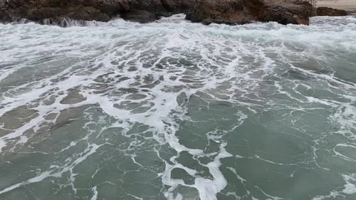 Dynamic Ocean Waves Crashing on Black Stones with Strong Motion