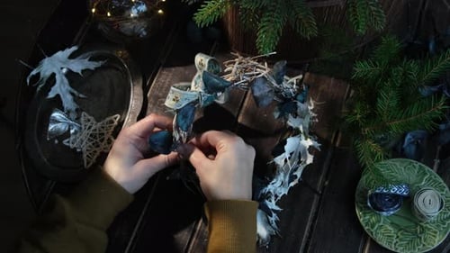 Hands Crafting Rustic Holiday Wreath at Home