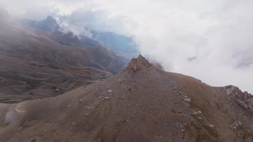 Luminous Sunlight Highlighting Rugged Mountainous Terrain Piercing Through Cloud Layers and Exposing