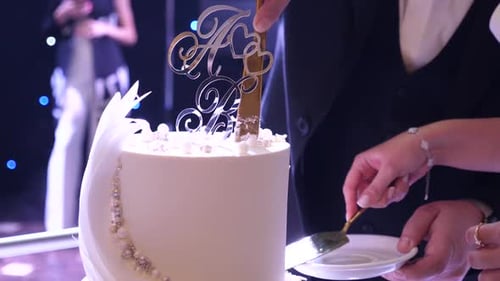 Close Up Of Couple Cutting Wedding Cake Together