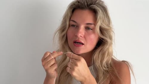 Schöne Frau ohne Make-up reinigt Zähne mit Zahnseide