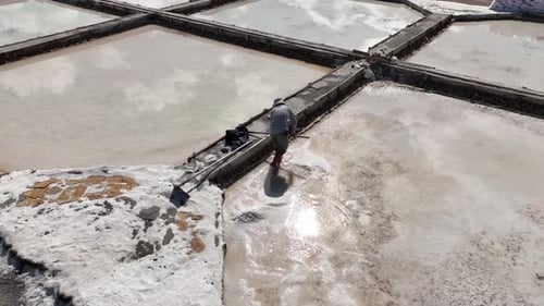 Aerial View Of Worker Working In Salt Ponds
