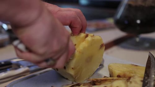 Hands Prepare a Fresh Pineapple with Knife