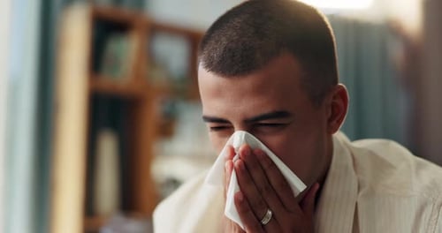 Young Adult Using Tissue For Runny Nose