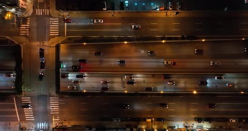 Top down aerial of traffic on major interstate highway at night in USA. Car truck vehicle headlights