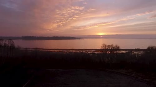 Lake Burtnieks im Spätherbst roter Himmel Sonnenuntergang Luftaufnahme mit Baumsilhouette