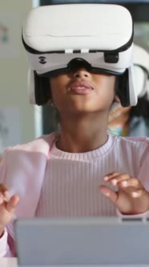 Vertical video: Lesson starting student wearing VR headset and pink top using tablet at school
