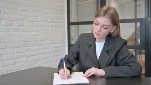 Businesswoman Writing a Letter in Office