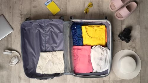 Stop Motion Animation Packing Suitcase With Colorful Clothes and Travel Accessories of Top View
