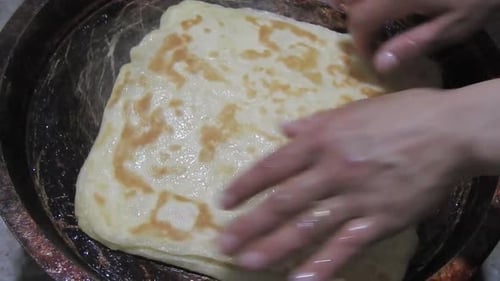 Special Moroccan pancakes called MSEMEN during the preparation in iron fryer