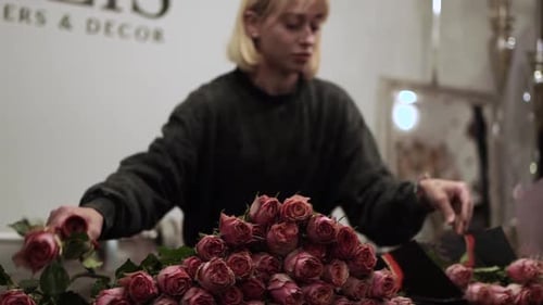 Florist sorting pink roses in the florist shop ES