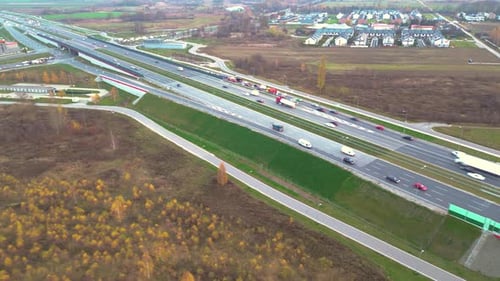 Aerial view of road junction with moving cars. Road interchange or highway intersection with busy ur
