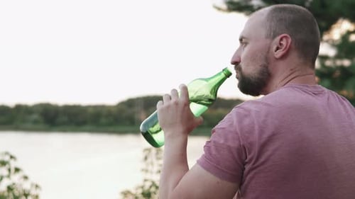 Un homme déprimé boit de l'alcool. Le concept de dépendance à l'alcool et de sans-abrisme.