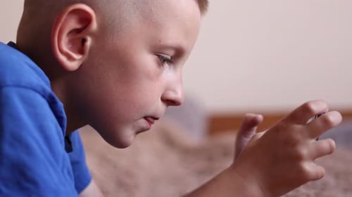 Child Focused on Mobile Device Indoors