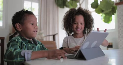 Two Happy Children Using Tablet Device at Home